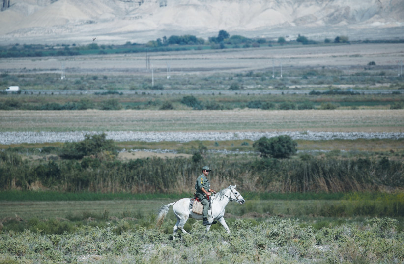 A SOLDIER rides a horse along the Baku-Tbilisi-Ceyhan crude oil pipeline after a cluster bomb hit the area, during the military conflict over Nagorno-Karabakh, near the city of Goranboy, Azerbaijan, earlier this month. (photo credit: REUTERS)