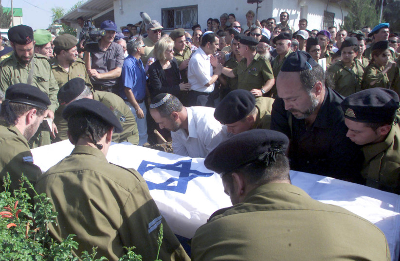 The coffin of Vadim Norzhich, draped in an Israeli flag, is lowered to his grave in Or Akiva ,October 13, 2000 (photo credit: HL/WS/REUTERS)