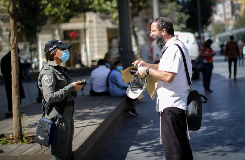 Israel Police officers check citizen's identification to keep coronavirus restricions, Jerusalem (photo credit: MARC ISRAEL SELLEM)