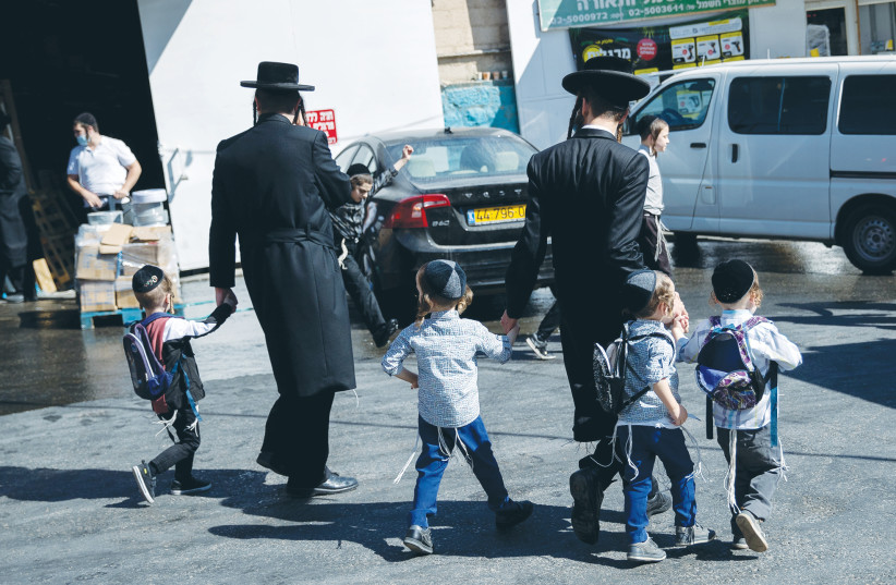 A FATHER walks his children home from school in Jerusalem on Sunday. (photo credit: YONATAN SINDEL/FLASH 90)