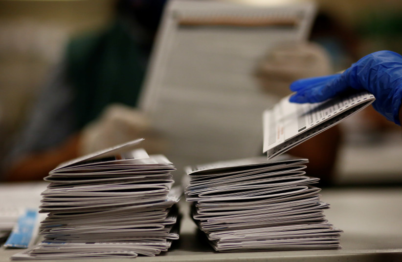 Mail-in ballots are processed and counted for the upcoming presidential election in Denver, Colorado, U.S., October 22, 2020. (photo credit: KEVIN MOHATT/REUTERS)