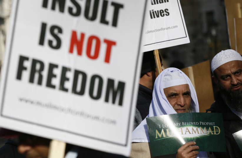 Muslim demonstrators hold placards during a protest against the publication of cartoons depicting the Prophet Mohammad in Charlie Hebdo in London (photo credit: REUTERS)