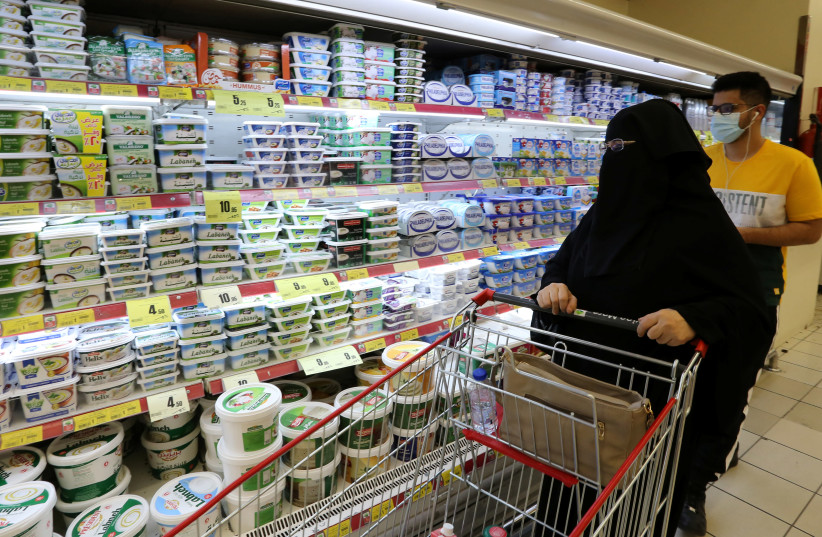 A Saudi woman looks at the dairy products in a supermarket, after Saudi Arabia's retail stores urged customers to boycott Turkish products, in Riyadh, Saudi Arabia, October 18, 2020 (photo credit: REUTERS/AHMED YOSRI)