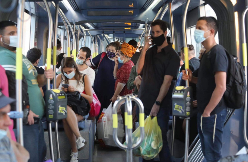 Israelis wearing masks crowd the Jerusalem light rail, October 2020. (photo credit: MARC ISRAEL SELLEM/THE JERUSALEM POST)