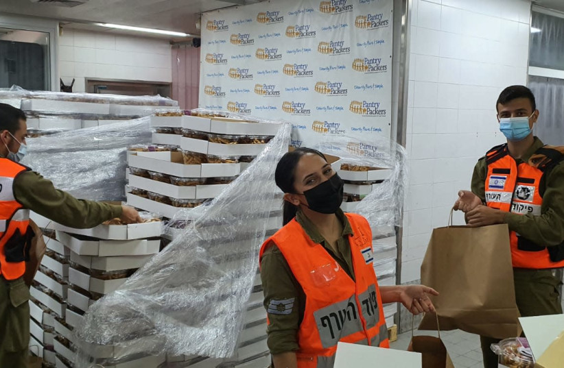 IDF soldiers are seen packing sweets at Colel Chabad's Pantry Packers to ship to coronavirus patients. (photo credit: PANTRY PACKERS)