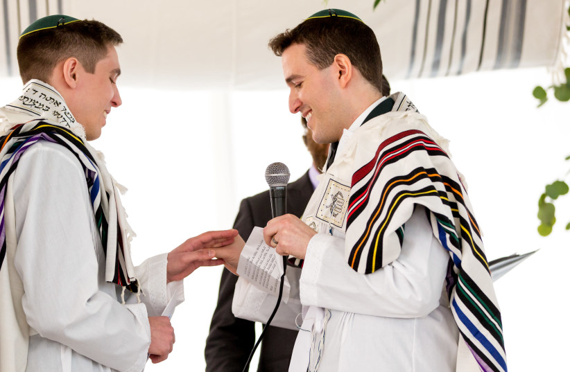Nadiv Schorer, right, married Ariel Meiri in 2020 with Orthodox rabbi Avram Mlotek officiating. (photo credit: DAVID PERLMAN PHOTOGRAPHY/JTA)