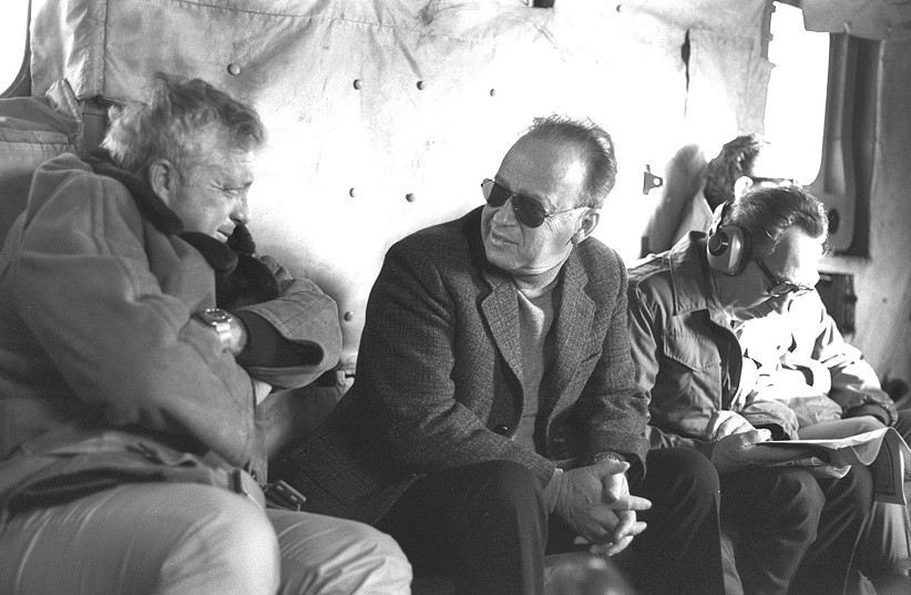 RABIN CONFERS with then-security advisor Ariel Sharon (left) as then-defense minister Shimon Peres reads on the right. (photo credit: YAACOV SAAR/GPO)