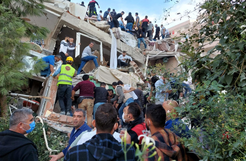 Locals and officials search for survivors at a collapsed building after a strong earthquake struck the Aegean Sea on Friday and was felt in both Greece and Turkey, where some buildings collapsed in the coastal province of Izmir, Turkey, October 30, 2020.  (photo credit: REUTERS)