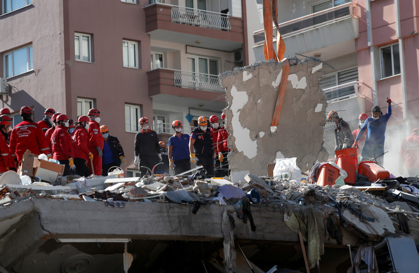 Rescue workers search for survivors at a collapsed building after an earthquake in the Aegean port city of Izmir, Turkey October 31, 2020 (photo credit: MURAD SEZER/REUTERS)