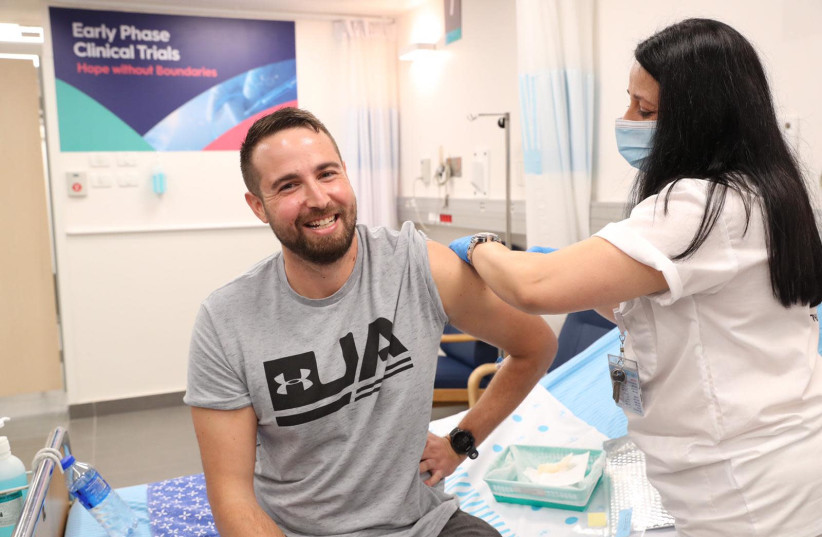Segev Harel becomes the first person to receive the IIBR's new coronavirus vaccine as human trials get underway, Sheba Medical Center, November 1, 2020 (photo credit: MINISTRY OF DEFENSE SPOKESPERSON'S OFFICE)
