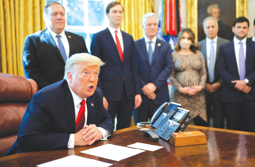 Us President Donald Trump uses a speakerphone to talk with leaders of Israel and Sudan, in the Oval Office at the White House last month. (photo credit: CARLOS BARRIA / REUTERS)