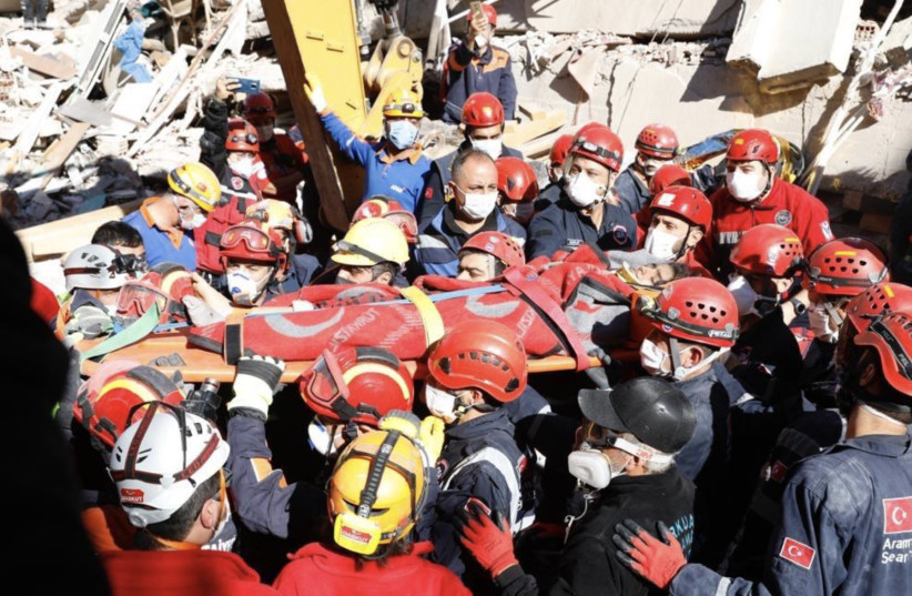 Rescue workers in Izmir, Turkey, are shown on Saturday removing a person who was trapped and injured in Friday’s earthquake. (photo credit: COURTESY CHP)