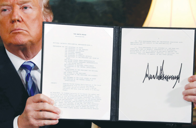 US president Donald Trump holds up a proclamation declaring his intention to withdraw the US from the Iran nuclear agreement,  at the White House in 2018. (photo credit: JONATHAN ERNST / REUTERS)