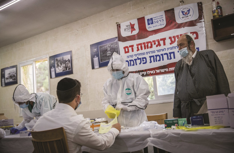 YAD AVRAHAM volunteers collect blood samples from haredi men who have recovered from COVID-19, at a Jerusalem yeshiva on October 27. Their plasma will be used to treat patients hospitalized with corona.  (photo credit: YONATAN SINDEL/FLASH 90)
