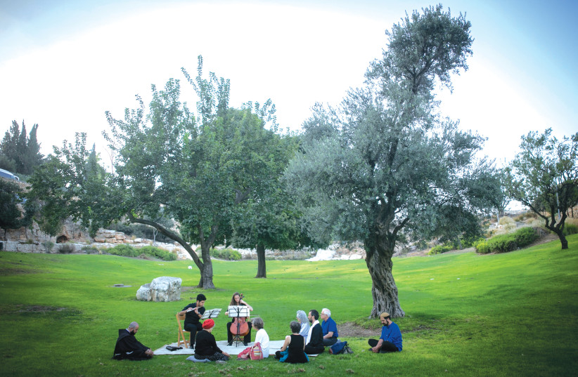 PEOPLE FROM various religious and cultural backgrounds listen to classical music during the Mekudeshet 2016 Festival, in Jerusalem’s Sacher Park. (photo credit: YONATAN SINDEL/FLASH 90)