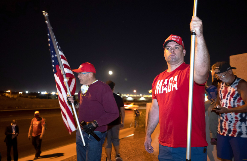 Supporters of US President Donald Trump, hold American flags during a "Stop the Steal" protest at the Clark County Election Center in North Las Vegas, Nevada, US November 4, 2020 (photo credit: REUTERS/STEVE MARCUS)