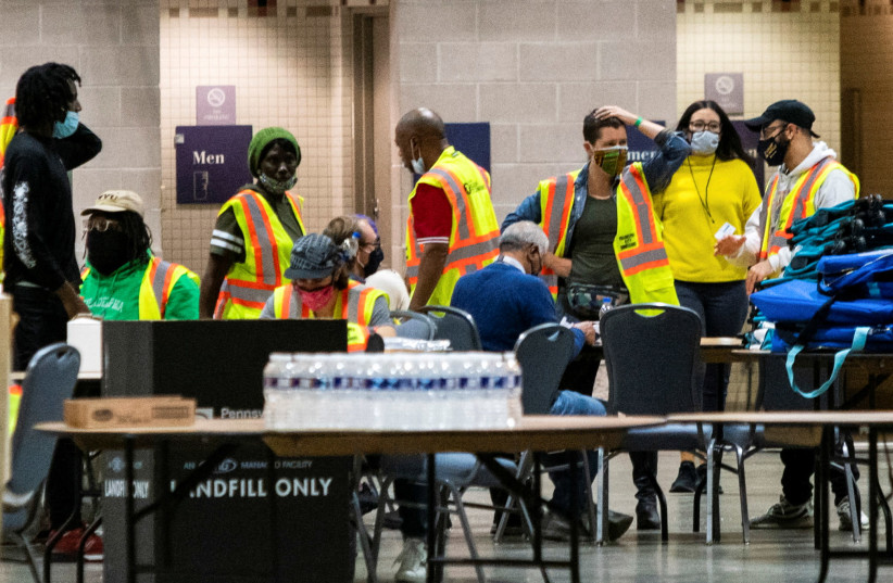 Electoral workers count postal ballots following the 2020 U.S. presidential election, in Philadelphia (photo credit: REUTERS)