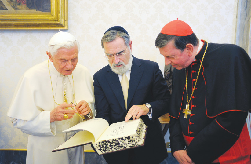 Pope Benedict XVI receives a gift by Lord Jonathan Sacks, chief rabbi of the United Hebrew Congregations of the Commonwealth, during a private audience at the Vatican in 2011.  (photo credit: OSSERVATORE ROMANO / AFP)