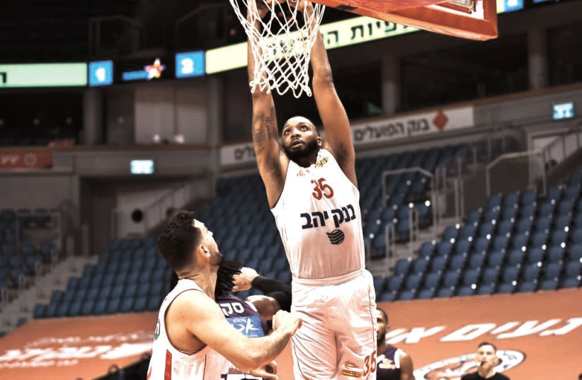  HAPOEL JERUSALEM FORWARD TaShawn Thomas converts an alley-oop dunk off a pass from teammate Tamir Blatt (unseen) during the Reds’ 91-82 victory over Ironi Nahariya on Sunday night at the capital’s Pais Arena. (photo credit: DOV HALICKMAN PHOTOGRAPHY)