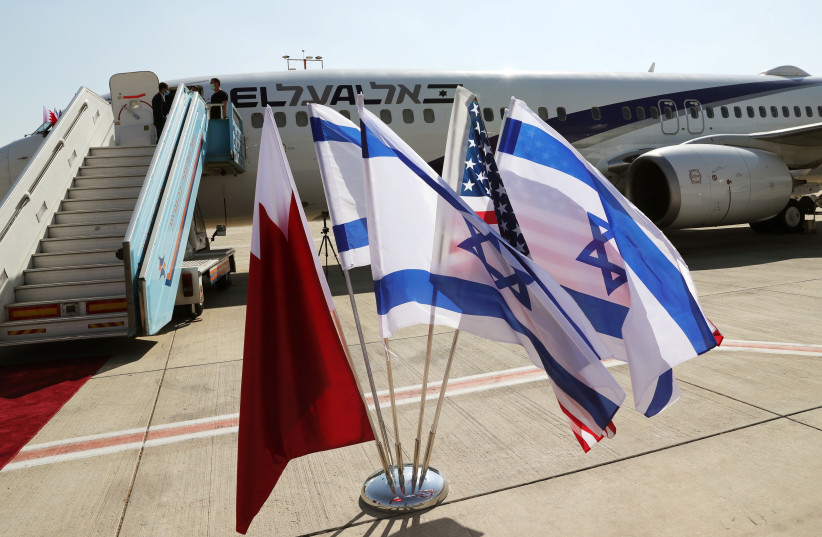 The national flags of Bahrain, Israel and America, flutter in near the Israeli flag carrier El Al plane, October 18, 2020 (photo credit: REUTERS/RONEN ZEVULUN)