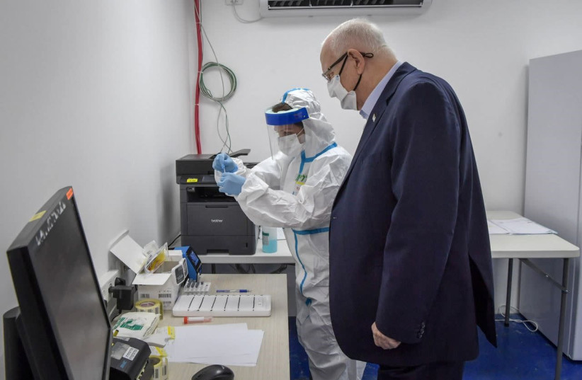 President Reuven Rivlin is administered the Sofia rapid antigen coronavirus test by Clalit staff in Ashkelon. (photo credit: GPO/KOBI GIDEON)