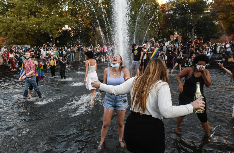 People celebrating the election of Joe Biden and Kamala Harris in Washington Square Park in New York City (photo credit: (STEPHANIE KEITH/GETTY IMAGES))
