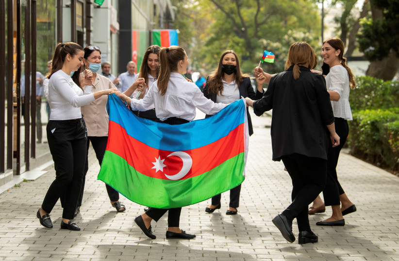 People take part in celebrations in a street following the signing of a deal to end the military conflict over the Nagorno-Karabakh region in Baku, Azerbaijan November 10, 2020 (credit: REUTERS/STRINGER)