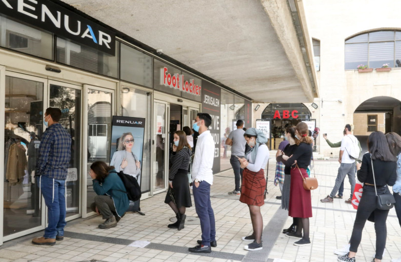 Shoppers line up at stores in Jerusalem as Israel continues the exit from the coronavirus lockdown, Nov. 10, 2020 (photo credit: MARC ISRAEL SELLEM)