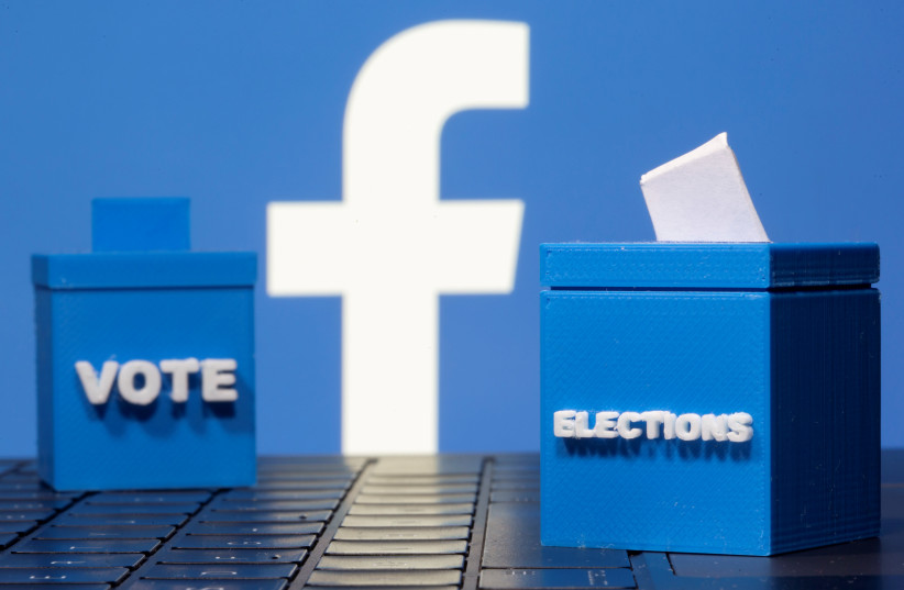 3D printed ballot boxes are seen in front of a displayed Facebook logo in this illustration taken November 4, 2020. (photo credit: REUTERS/DADO RUVIC/ILLUSTRATION/FILE PHOTO)