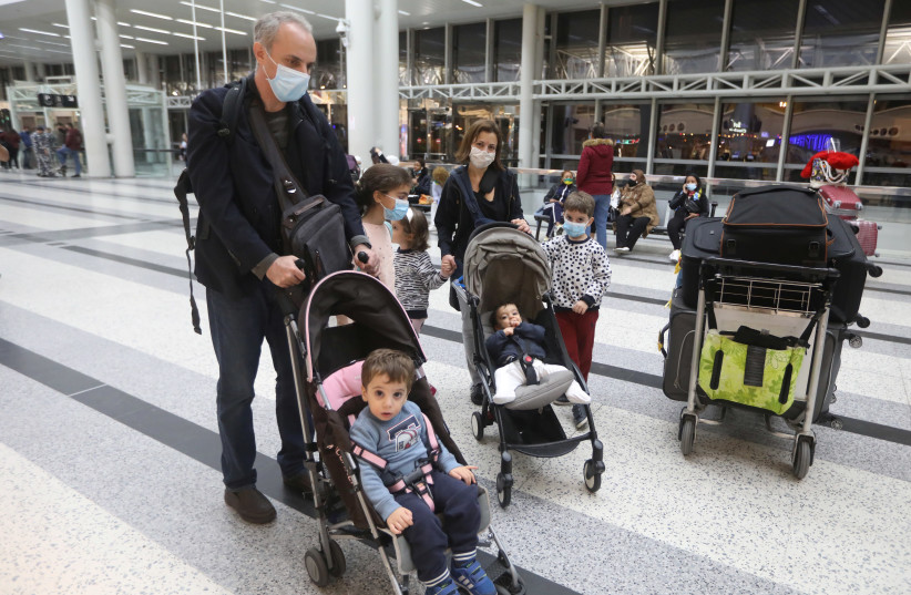 Dr. Fouad Boulos, Associate Professor of Clinical Pathology and Laboratory Medicine at the American University of Beirut (AUB) pushes a baby cart near his wife and children, at Beirut International airport (photo credit: REUTERS)