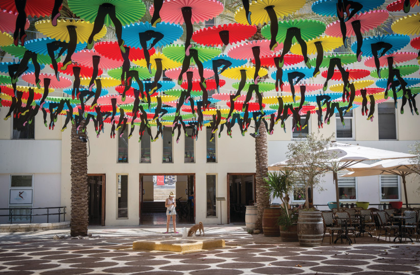 COLORFUL UMBRELLAS with ‘dancing feet’ adorn the the Suzanne Dellal Center plaza, in Tel Aviv’s Neve Tzedek in 2018 (photo credit: MIRIAM ALSTER/FLASH90)