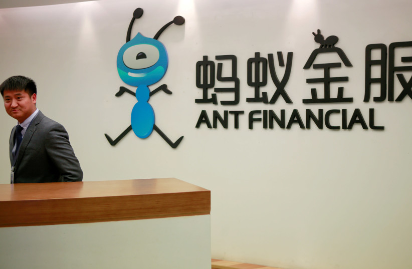 An employee stands next to the logo of Ant Financial Services Group, Alibaba's financial affiliate, at its headquarters in Hangzhou, Zhejiang province, China January 24, 2018. (photo credit: SHU ZHANG/REUTERS)