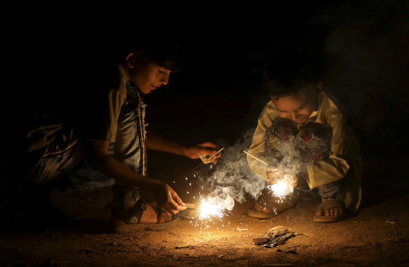 Children light firecrackers during Diwali, the Hindu festival of lights, in Mumbai, India, November 14, 2020.  (photo credit: REUTERS/FRANCIS MASCARENHAS)