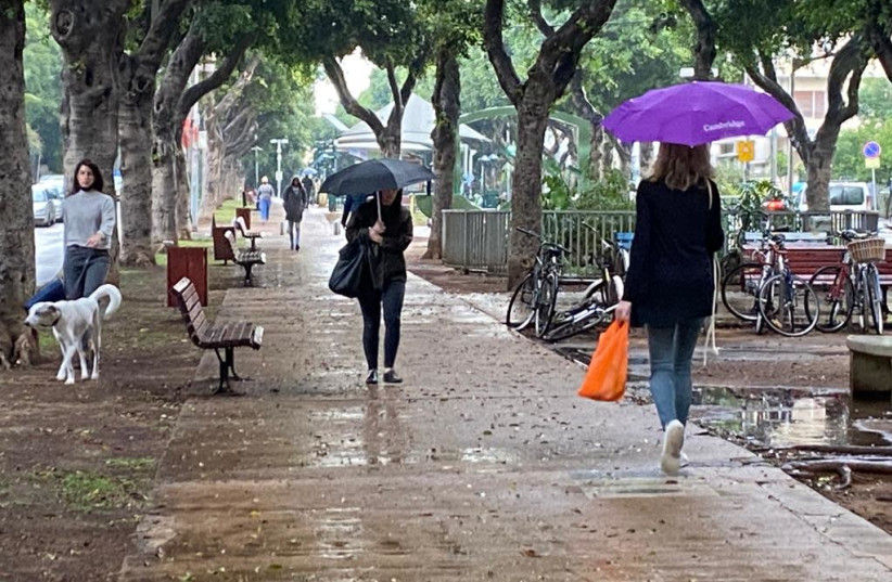 Shoppers put their umbrellas to good use as the rain comes down in Tel Aviv, November 15, 2020 (photo credit: COURTESY/MAARIV)