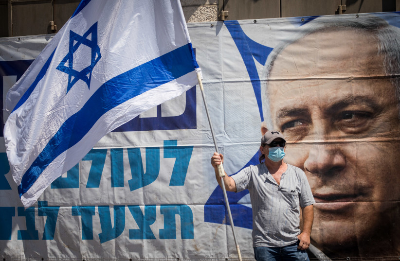 Supporters of Prime Minister Benjamin Netanyahu protest outside the District Court in Jerusalem, during a court hearing of his trial on criminal allegations of bribery, fraud and breach of trust, July 19, 2020 (photo credit: YONATAN SINDEL/FLASH90)