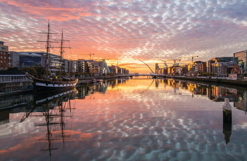 SUNRISE ON the River Liffey paints the calm waters in a rainbow of colors (photo credit: ILAN ROGERS)