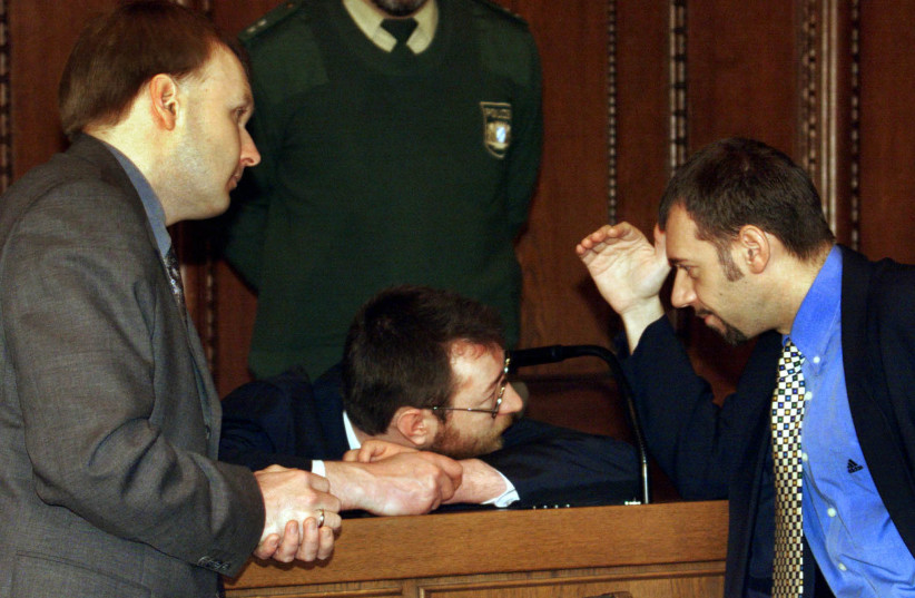 WERNER ARNOLD (center) talks to his attorneys in a courtroom in 1998 in Nuremberg, the site of the Nazi war-crimes trial discussed in the book. Arnold was accused of the rape and murder of an 11-year-old German girl. (photo credit: REUTERS)