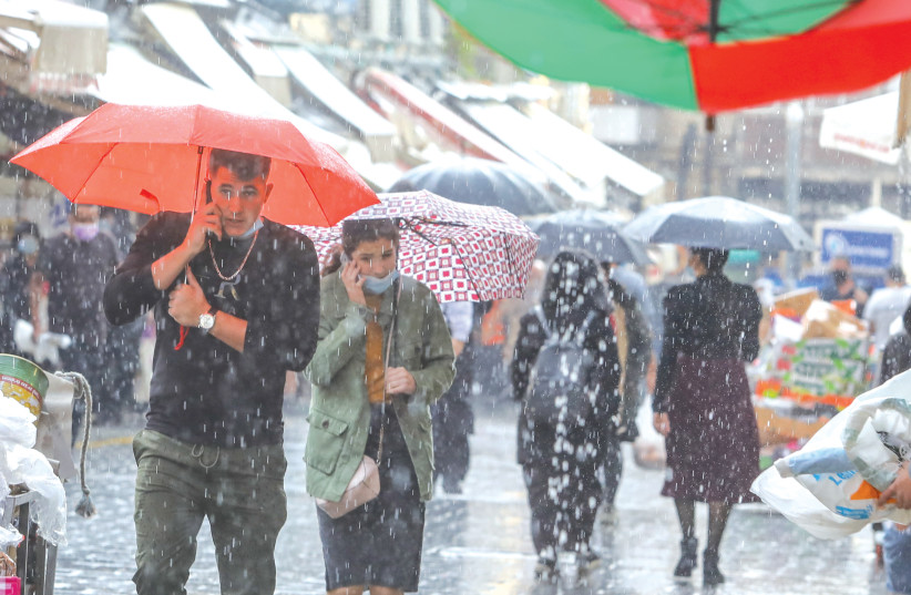 WINTER WEATHER hits Jerusalem this week as shoppers in the Mahaneh Yehuda market brave the rain. (photo credit: MARC ISRAEL SELLEM/THE JERUSALEM POST)
