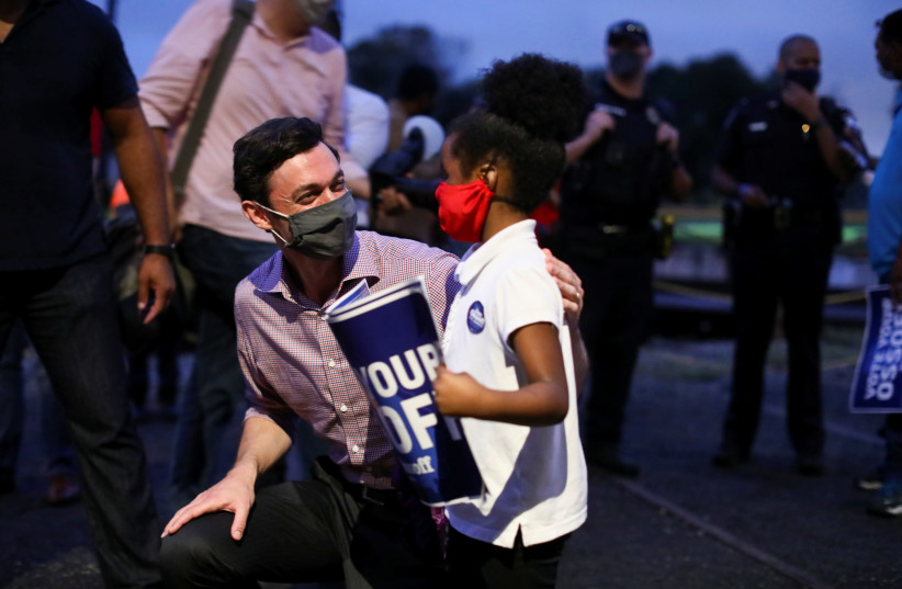  Democratic US Senate candidate Jon Ossoff greets a supporter after speaking at a campaign event at the Georgia State Railroad Museum in Savannah, Georgia, US November 12, 2020. (photo credit: REUTERS/DUSTIN CHAMBERS)