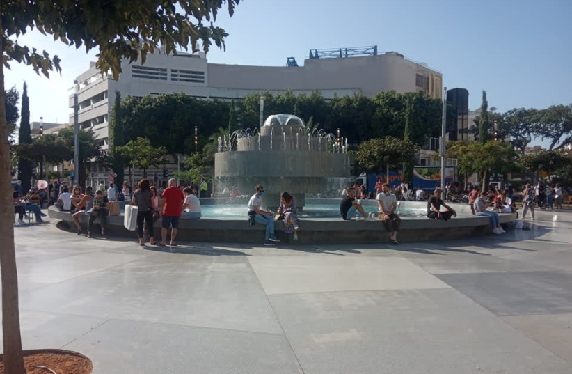 The fountain on Dizengoff Square in Tel Aviv. City residents are enjoying the sun as business owners feel greater and greater insecurity about the future. (photo credit: HAGAY HACOHEN)