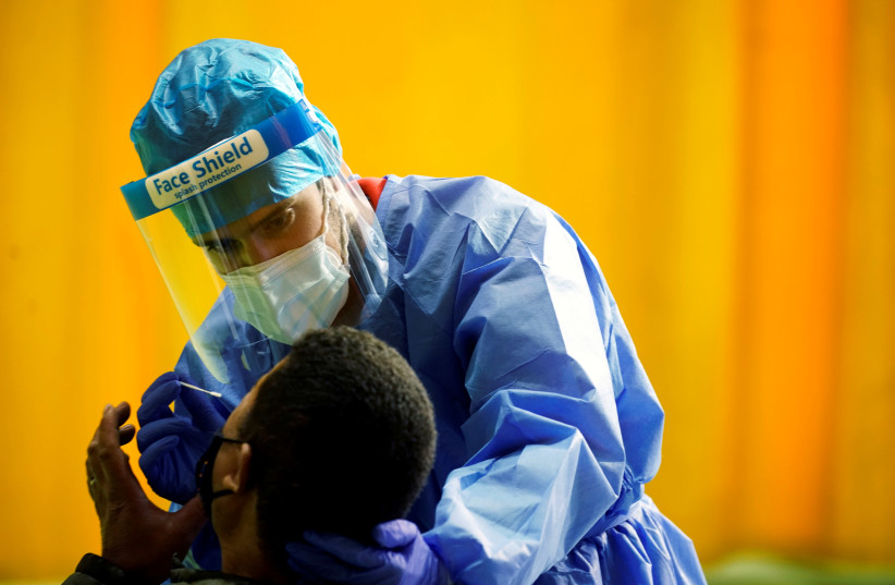 A healthcare worker performs a rapid COVID-19 antigen test amid the coronavirus disease (COVID-19) outbreak in Alpedrete, Spain, November 16, 2020.  (photo credit: REUTERS/JUAN MEDINA/FILE PHOTO)