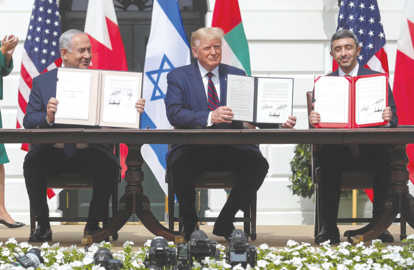 PRIME MINISTER Benjamin Netanyahu, US President Donald Trump and United Arab Emirates Foreign Minister Abdullah bin Zayed display their copies of signed agreements normalizing relations between Israel and the UAE, in Washington, in September. (photo credit: TOM BRENNER/REUTERS)