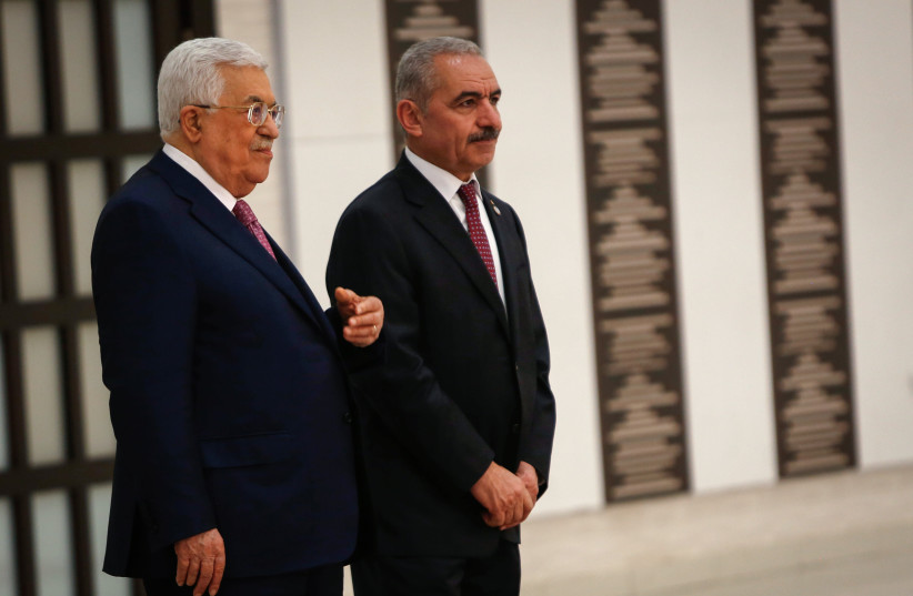 Palestinian Prime Minister Mohammad Ishtayeh (R) and President Mahmoud Abbas (L) at the  swearing in ceremony of the new government at the Palestinian Authority's headquarters in the West Bank town of Ramallah, April 13, 2019. (credit: NASSER ISHTAYEH/FLASH90)