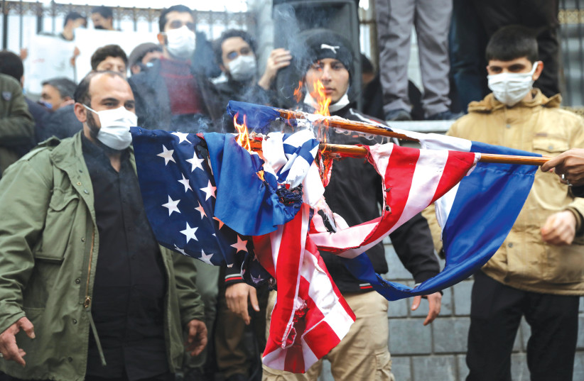 PROTESTERS ON Saturday burn US and Israel flags during a demonstration against the the killing of Mohsen Fakhrizadeh, Iran’s top nuclear scientist, in Tehran. (photo credit: MAJID ASGARIPOUR/WANA (WEST ASIA NEWS AGENCY) VIA REUTERS)