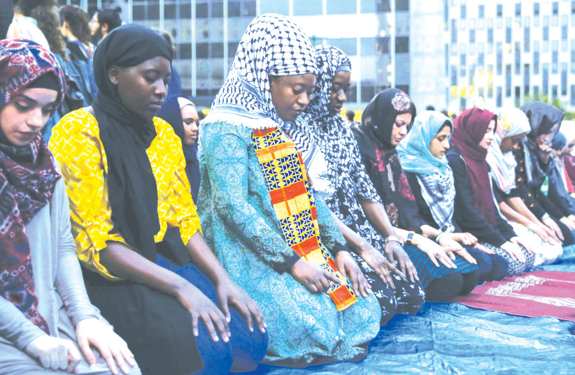 MUSLIM WOMEN recite sunset prayers outside ICE’s New York field office in New York City in 2018. (photo credit: AMR ALFIKY/ REUTERS)