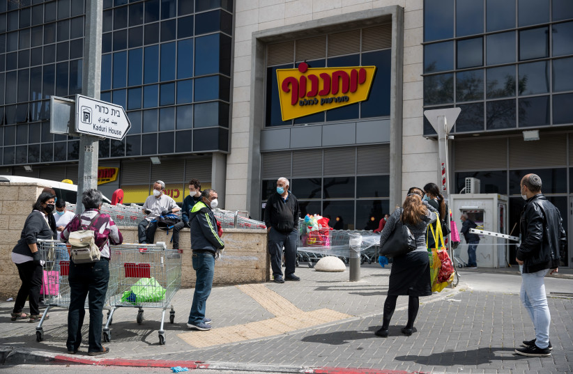 People waiting in line outside Yochananof supermarket in Jerusalem on April 7, 2020. The government ordered on a partial lockdown, in order to prevent the spread of the coronavirus. (photo credit: YONATAN SINDEL/FLASH 90)