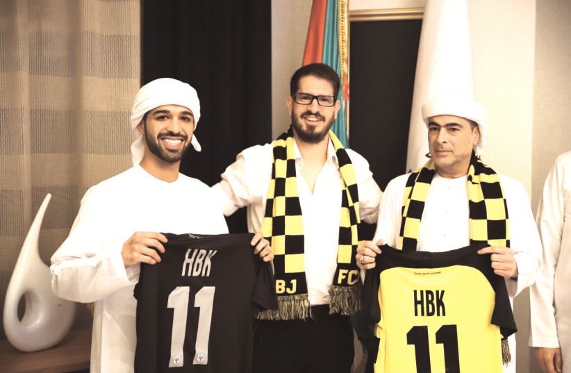 Beitar Jerusalem co-owners Moshe Hogeg (center) and Sheikh Hamad bin Khalifa Al Nahyan (right) pose with the sheikh’s son, Mohamed, after signing their historic partnership agreement on Monday evening. (photo credit: BEITAR JERUSALEM/COURTESY)