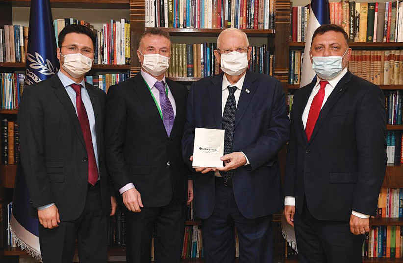 PRESIDENT REUVEN RIVLIN holds a book of Jabotinsky’s essays alongside leaders of the Euro-Asian Jewish Congress. (photo credit: Courtesy)