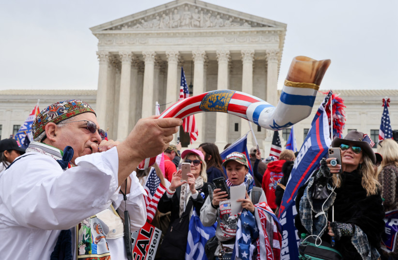 A man blows a shofar as supporters of US President Donald Trump rally to protest the results of the election in front of Supreme Court building, in Washington, US, December 12, 2020.  (photo credit: REUTERS)