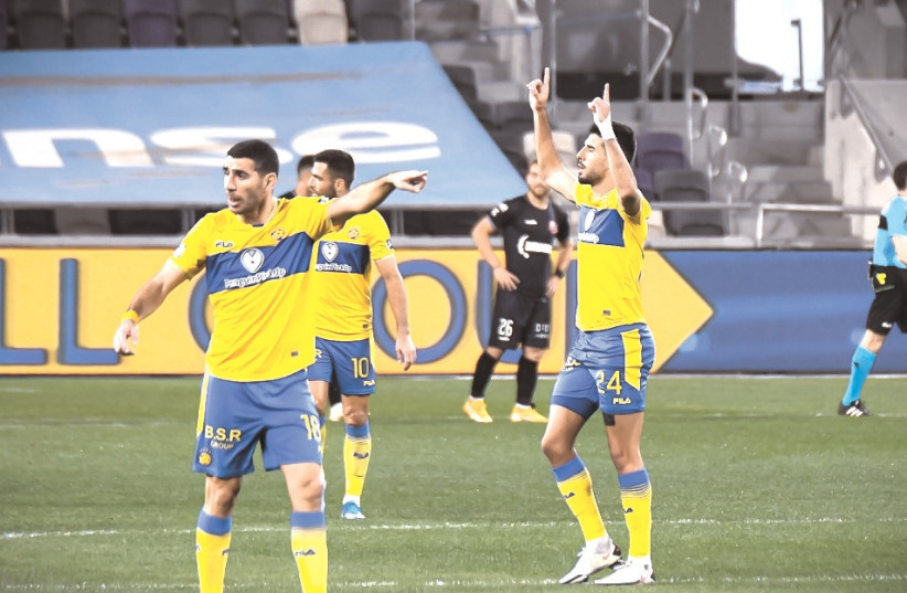 MACCABI TEL AVIV players celebrate at the end of their enthralling 4-3 comeback victory over Hapoel Haifa on Sunday night at Bloomfield Stadium. (photo credit: ARIEL SHALOM)